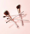 Makeup Brushes stacked on a pink background